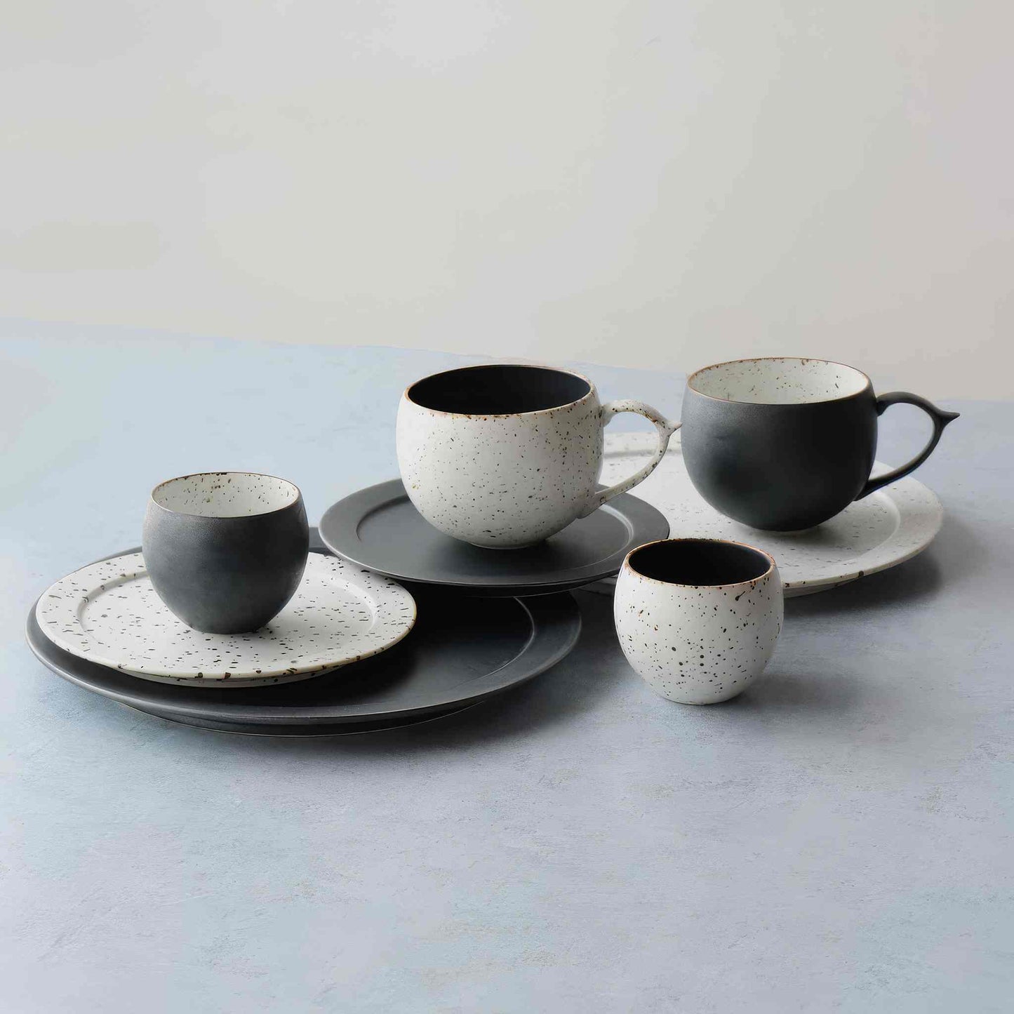 Handmade black and white plate with natural speckled glaze, evoking Arita ware's celebrated tradition.