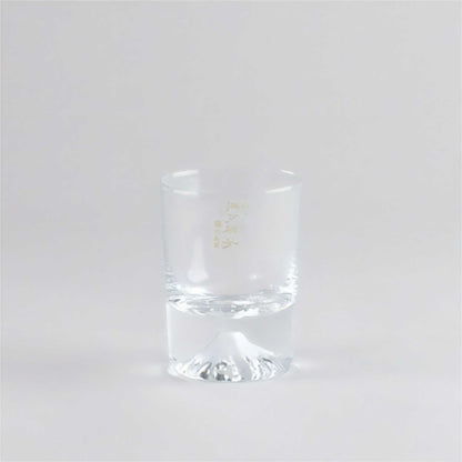 Clear glass tumbler with a gold logo on a white background