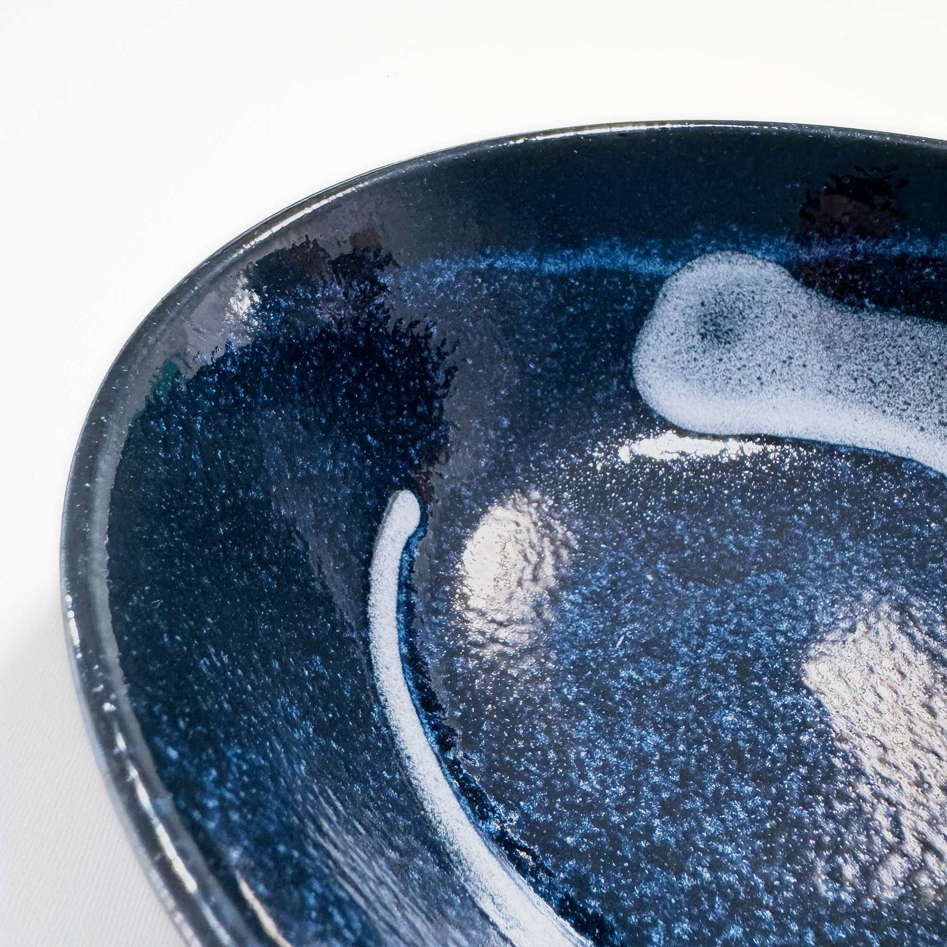 A portion of a dark blue, speckled Mino Ware Porcelain Ramen Bowl, set against a white background.