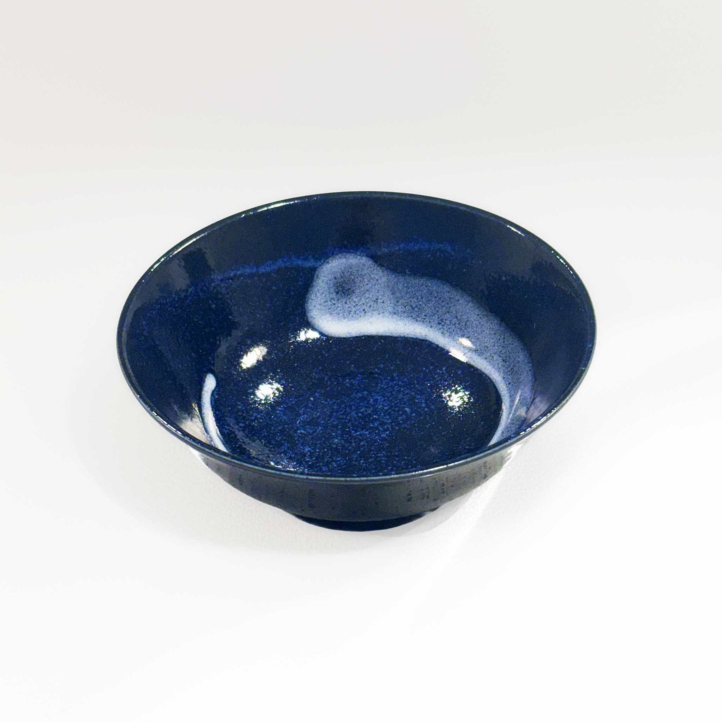 A dark blue, speckled glaze Mino Ware Porcelain Ramen Bowl, made from high-quality ceramic materials, sits on a plain white background.