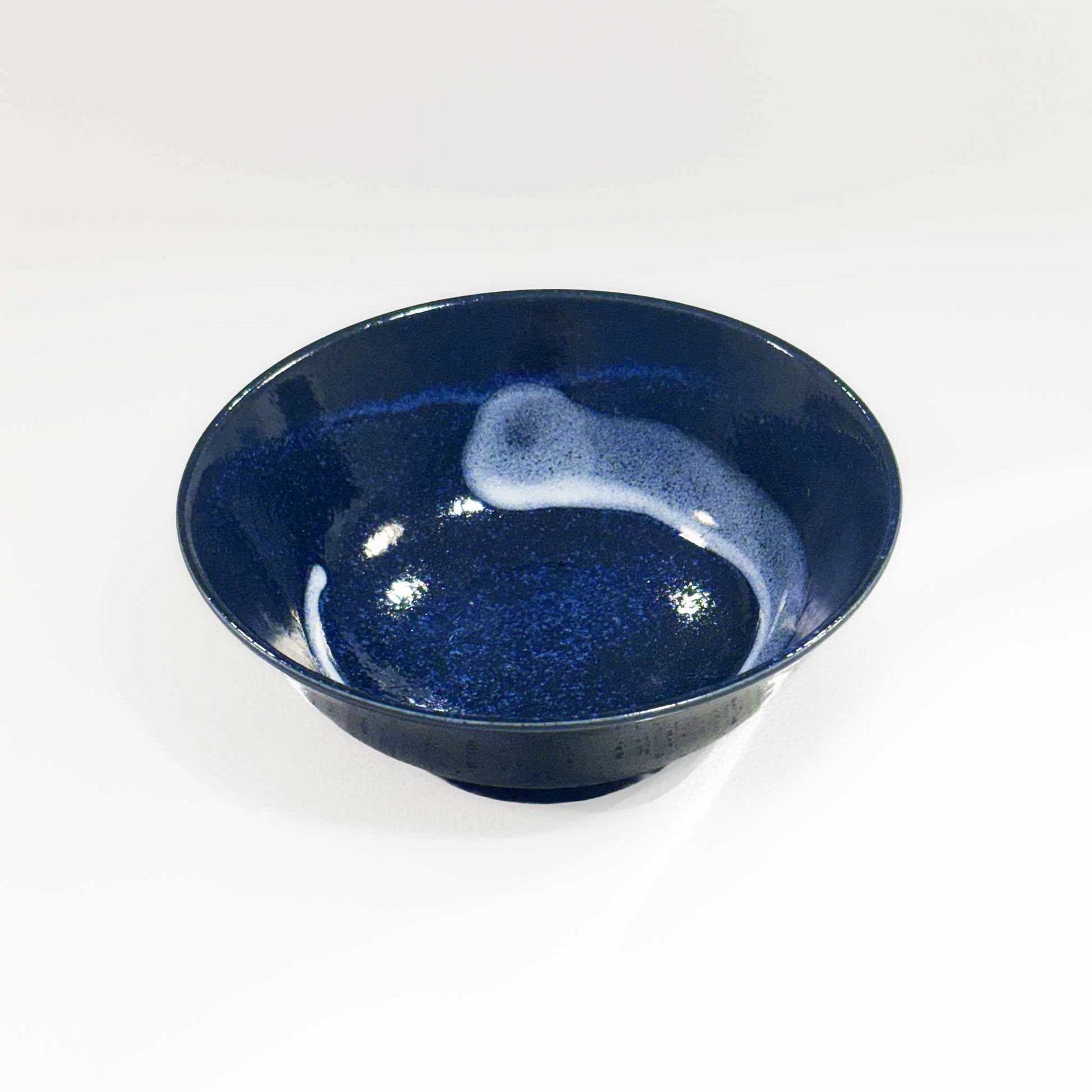 A dark blue, speckled glaze Mino Ware Porcelain Ramen Bowl, made from high-quality ceramic materials, sits on a plain white background.