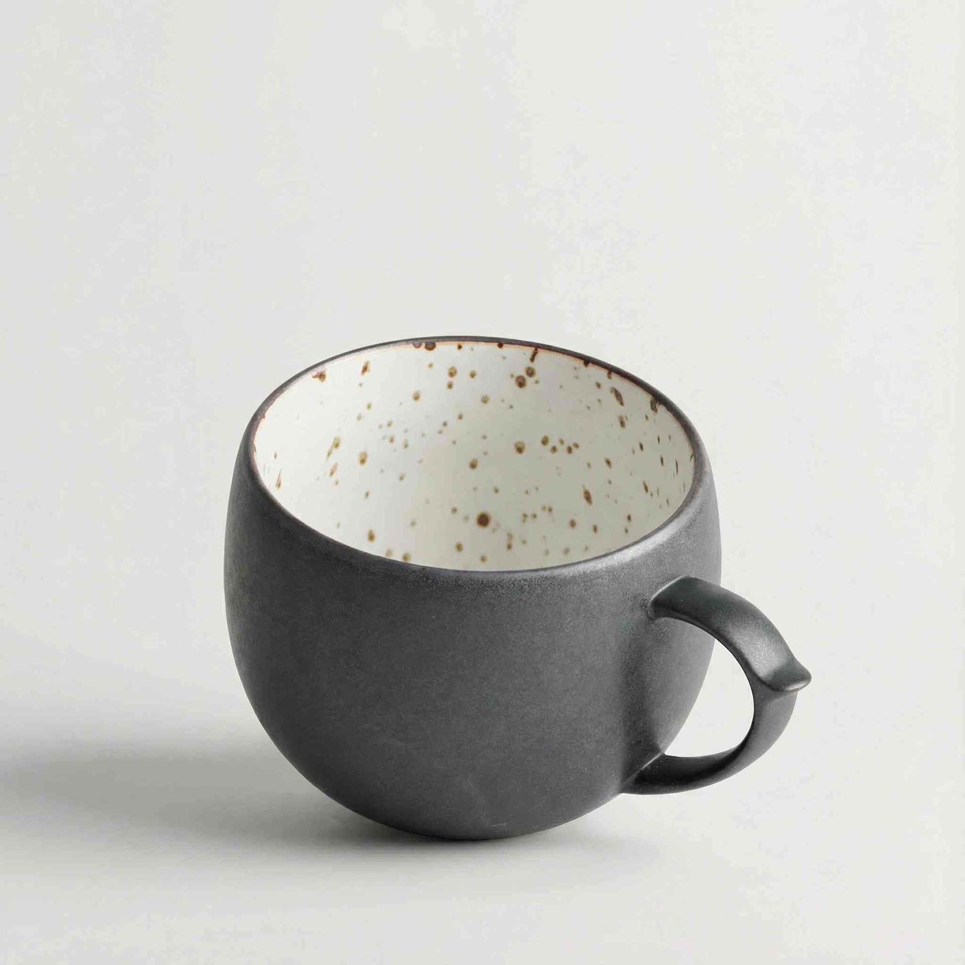 Handcrafted black and white wabi-sabi ceramic mug with saucer, Arita ware.