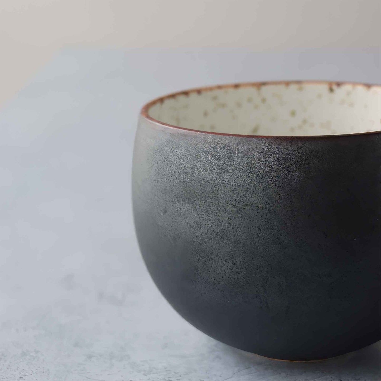 Handcrafted black and white wabi-sabi ceramic mug with saucer, Arita ware.