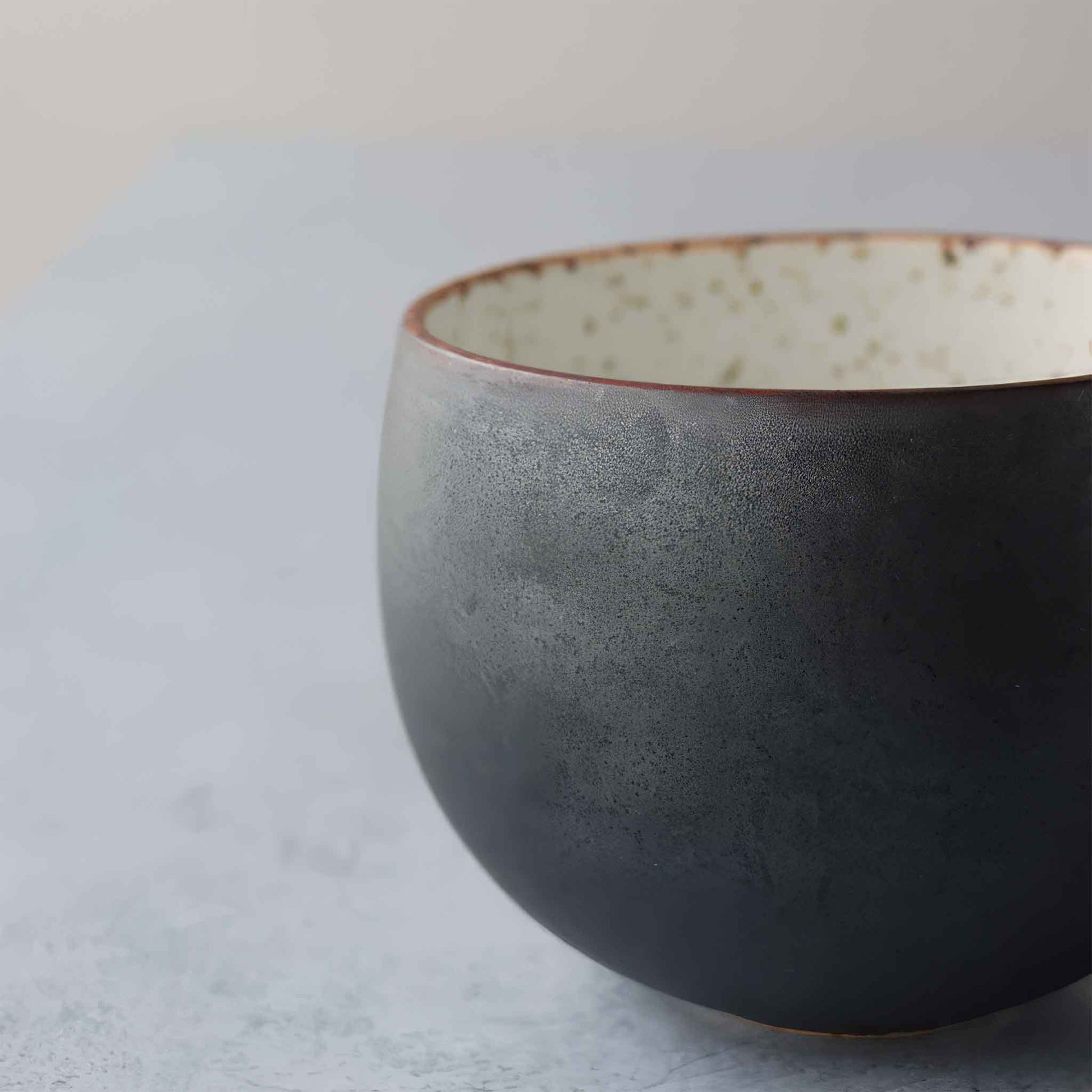 Handcrafted black and white wabi-sabi ceramic mug with saucer, Arita ware.