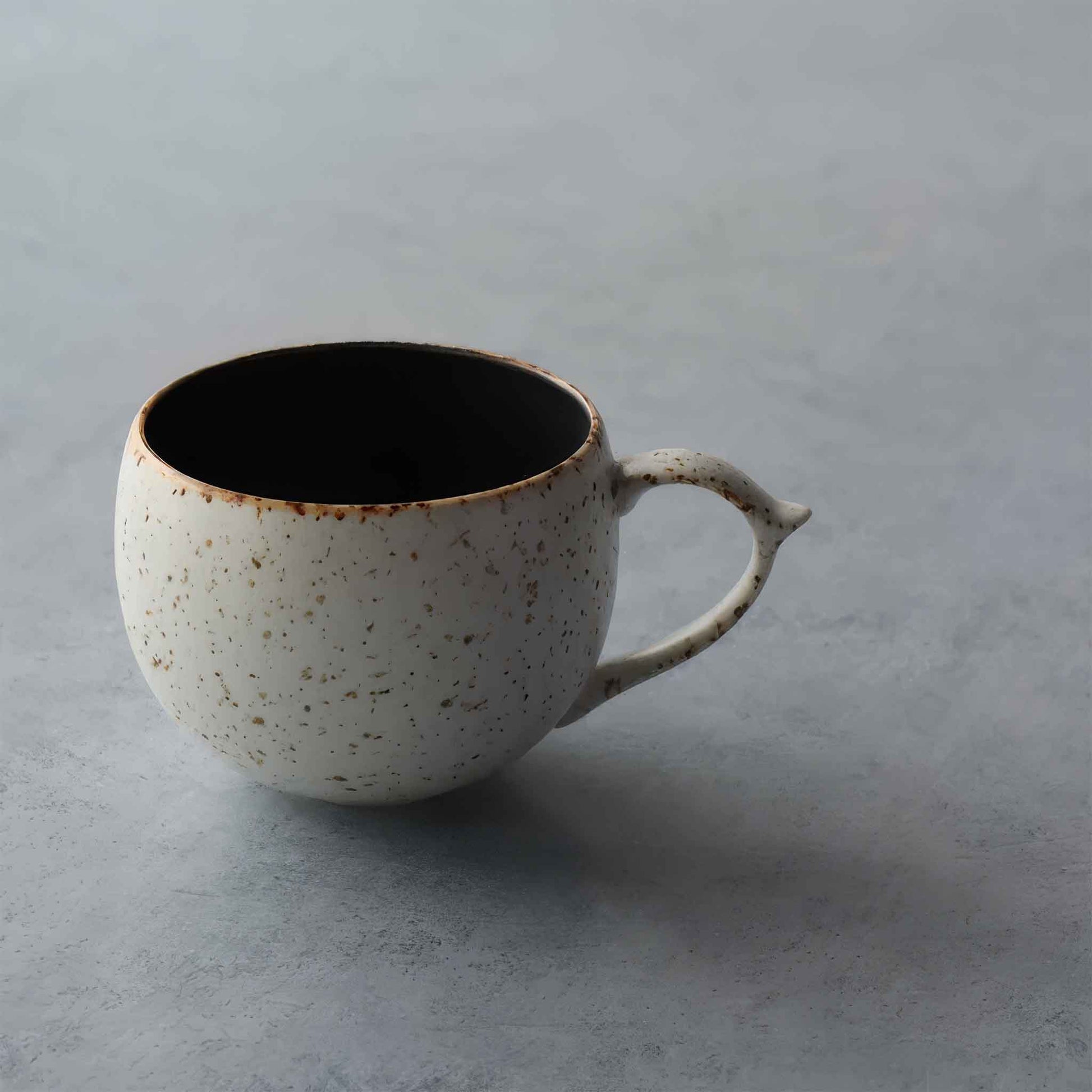 Handcrafted in Arita, Japan, this black and white mug with a unique, imperfect design embodies the wabi-sabi philosophy.