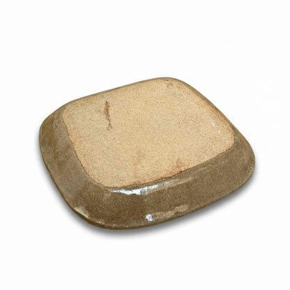 A handcrafted, square-shaped plate with a natural, earthy tone, made from slipware by Japanese ceramicist Momoko Shiohata.