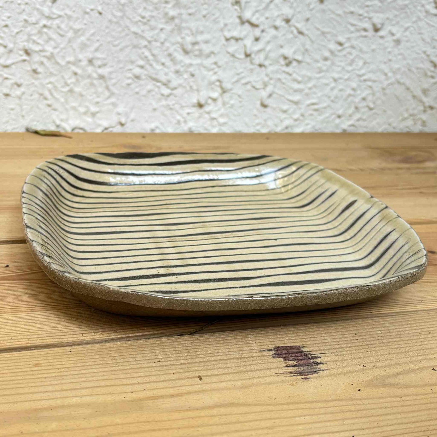 Handmade slipware square plate with unique, hand-applied surface patterns.