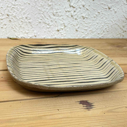 Handmade slipware square plate with unique, hand-applied surface patterns.