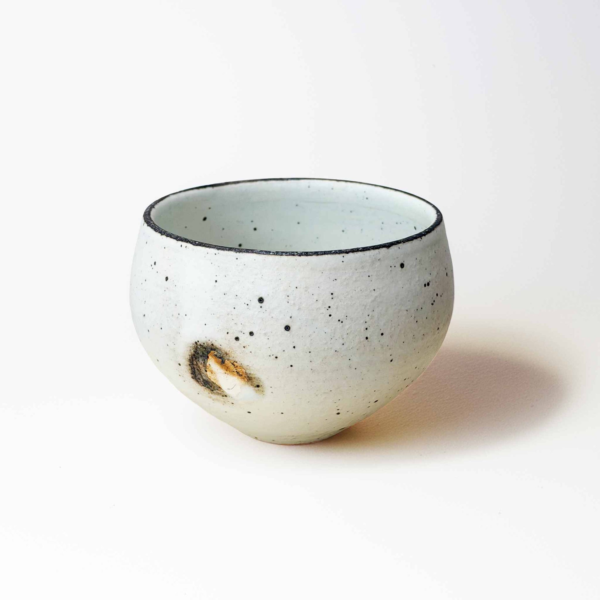 Speckled ceramic bowl on a plain background