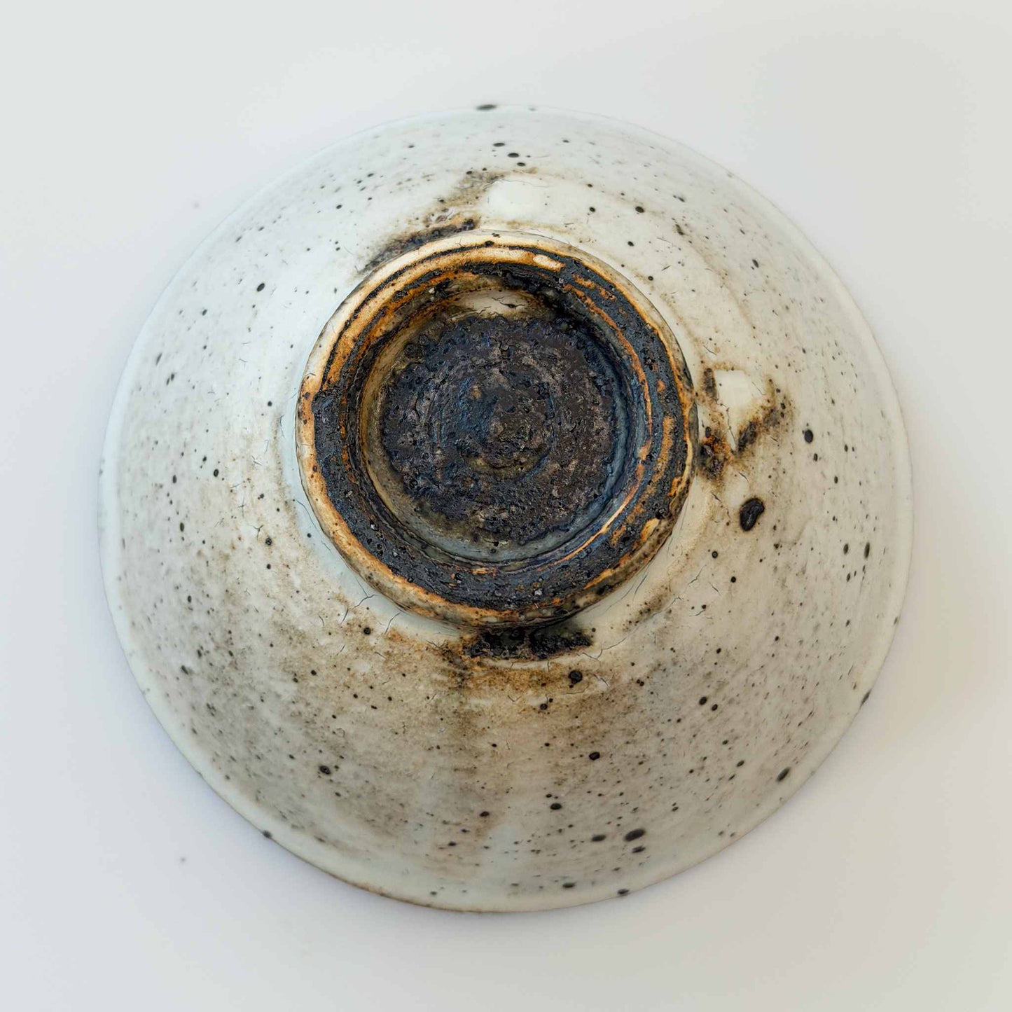 A white, hand-thrown V-shaped bowl with a kohiki glaze, set against a plain white background.