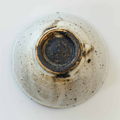 A white, hand-thrown V-shaped bowl with a kohiki glaze, set against a plain white background.