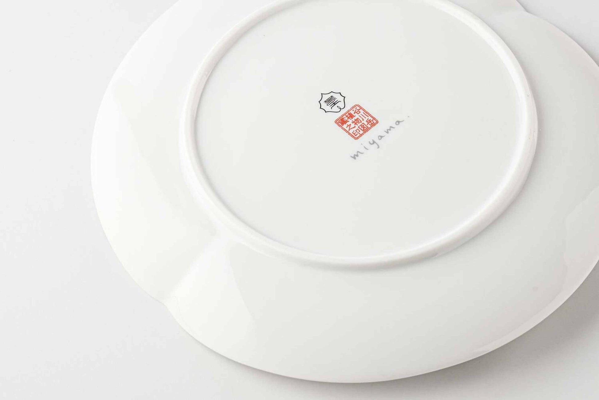 Side view of 8-inch white Mino ware plate with Yezo hydrangea botanical design.